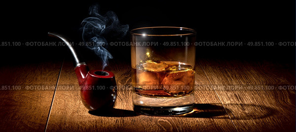 Tobacco pipe and glass of scotch on wooden table. Стоковое фото, агентство Ingram Publishing / Фотобанк Лори