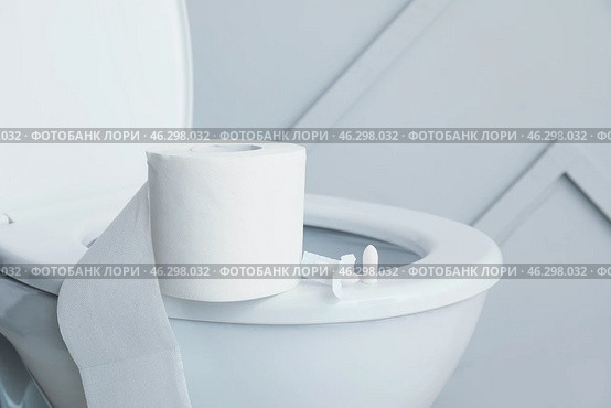 Toilet bowl with roll of paper and hemorrhoidal suppositories in restroom. Стоковое фото, фотограф Pixel_shot / Фотобанк Лори