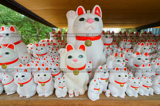 Tokyo, Japan - Sep 30 2024, A close-up view of many multi-sized white beckoning cat figure of Maneki neko with red ears and noses displayed at Gotokuji Temple, without people, at daytime, Tokyo, Japan. Стоковое фото, фотограф Сергей Богомяко / Фотобанк Лори
