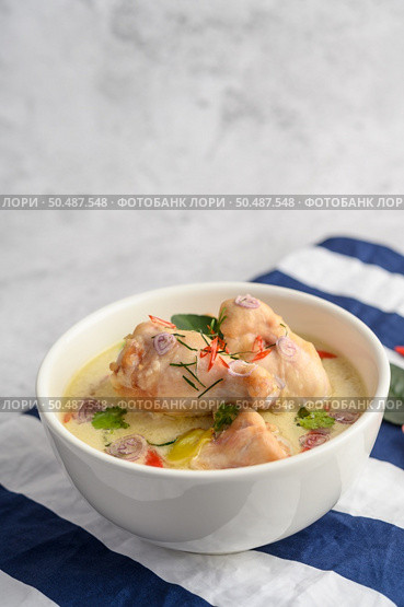 Tom Kha Kai in a bowl with kaffir lime leaves, lemongrass, red onion, galangal and chilli.Selective focus. Стоковое фото, агентство Ingram Publishing / Фотобанк Лори