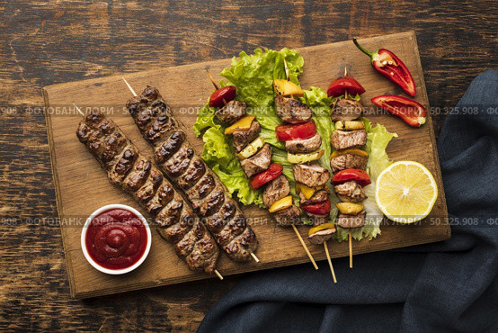 top view chopping board with delicious kebab lemon. Resolution and high quality beautiful photo. top view chopping board with delicious kebab lemon. High quality beautiful photo concept. Стоковое фото, агентство Ingram Publishing / Фотобанк Лори