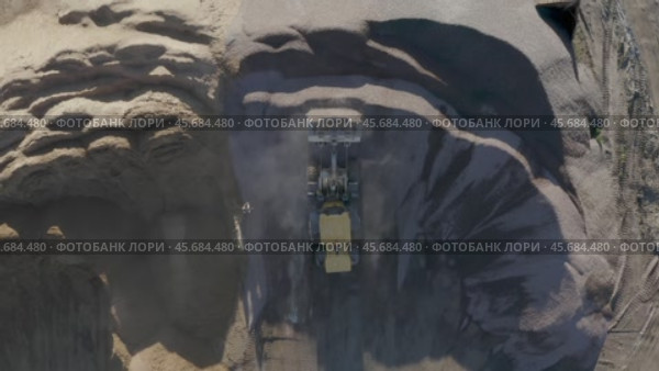 Top view of a sand quarry with a bulldozer working with concrete. Стоковое видео, видеограф Николай Титюк / Фотобанк Лори