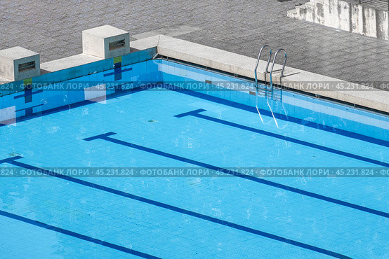 Top view swimming pool outlined by bold lanes, inviting swimmers to glide through clear turquoise water. lanes, neatly divided by marker lines, perfect for training and competition. Стоковое фото, фотограф Павел Муравьев / Фотобанк Лори