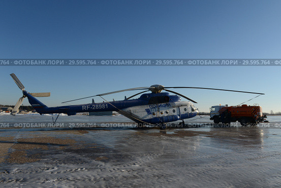 Топливозаправщик заправляет вертолёт МИ - 8АМТ на аэродроме Мячково (2016 год). Редакционное фото, фотограф Free Wind / Фотобанк Лори