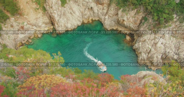 Tour boat navigating into turquoise cove surrounded by rocky cliffs in Capri. Стоковое видео, видеограф Ольга Сухарева / Фотобанк Лори