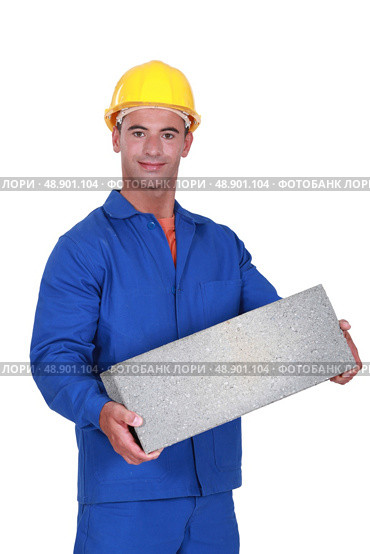 Tradesman carrying a cinder block. Стоковое фото, агентство Ingram Publishing / Фотобанк Лори