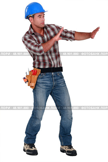 Tradesman trying to protect himself from a shooting object. Стоковое фото, агентство Ingram Publishing / Фотобанк Лори