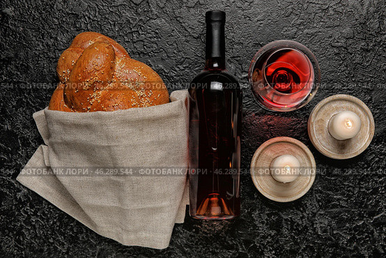 Traditional challah bread with wine and candles on dark background. Shabbat Shalom. Стоковое фото, фотограф Pixel_shot / Фотобанк Лори