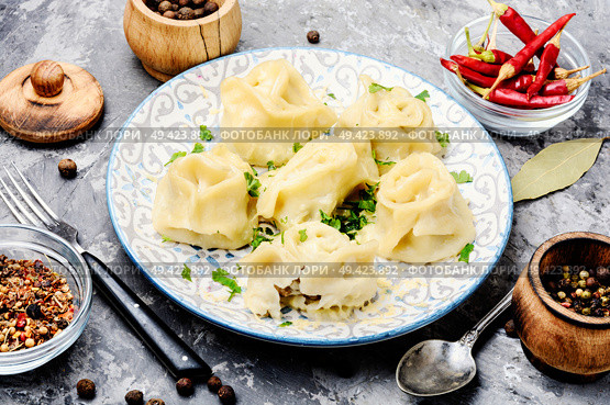 Traditional Russian dish pelmeni.Meat dumplings on rustic background. Dumplings with meat. Стоковое фото, агентство Ingram Publishing / Фотобанк Лори
