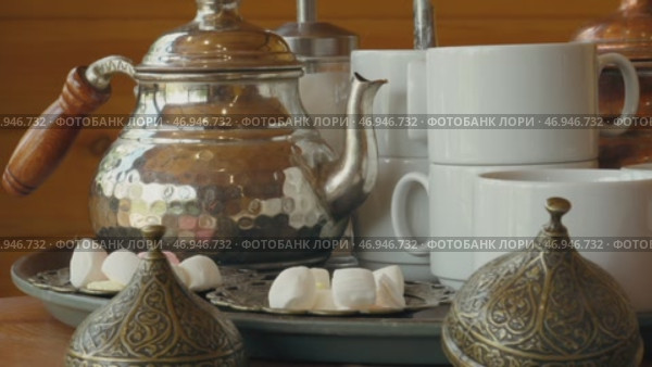 Traditional tea service with silver teapot and sugar sweets in a cozy cafe setting. Стоковое видео, видеограф Сергей Толмачёв / Фотобанк Лори