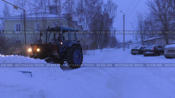 Трактор убирает снег с проезжей части. Tractor removes snow from the roadway. (2019 год). Стоковое видео, видеограф Евгений Романов / Фотобанк Лори
