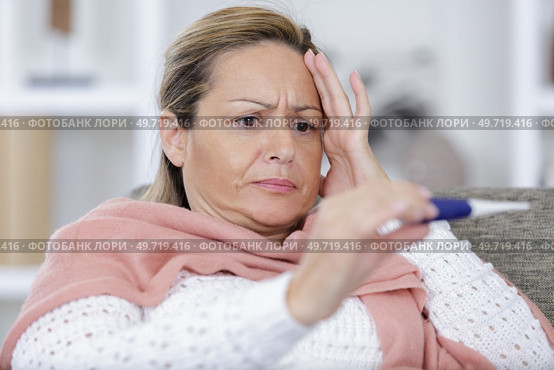 troubled woman measuring her temperature. Стоковое фото, агентство Ingram Publishing / Фотобанк Лори