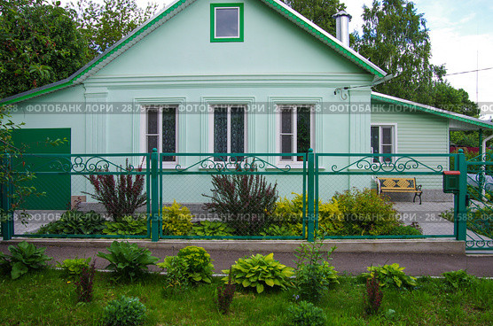 Цветник с декоративно-лиственными кустарниками перед загородным домом. Стоковое фото, фотограф Natalia Sidorova / Фотобанк Лори