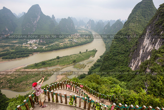 Турист делает селфи с Xianggong Hill недалеко от поселка Синпин, Китай. Стоковое фото, фотограф Николай Винокуров / Фотобанк Лори