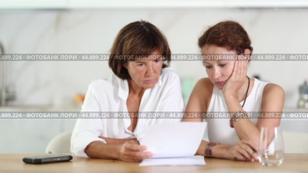 Two adult women discuss documents, try to solve financial problems. Стоковое видео, видеограф Яков Филимонов / Фотобанк Лори