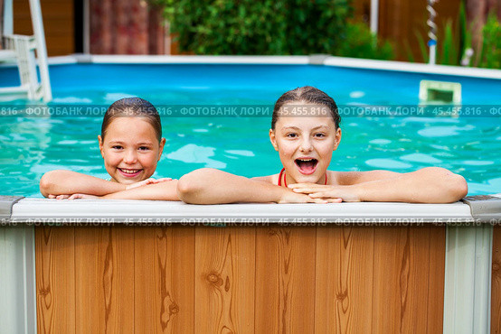 Two beautiful girls sisters pose in a home pool. Стоковое фото, фотограф Андрей Аркуша / Фотобанк Лори