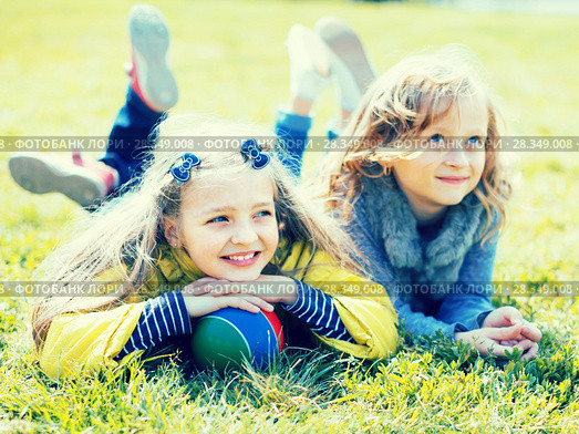 two blonde girl lie on grass in spring. Стоковое фото, фотограф Татьяна Яцевич / Фотобанк Лори