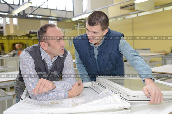 two careful workmen work at pvc windows factory. Стоковое фото, агентство Ingram Publishing / Фотобанк Лори