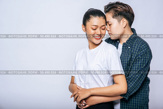 Two female lovers standing and hugging from behind. Стоковое фото, агентство Ingram Publishing / Фотобанк Лори