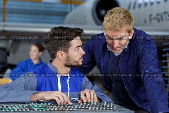 two flight engineers working in hangar. Стоковое фото, агентство Ingram Publishing / Фотобанк Лори