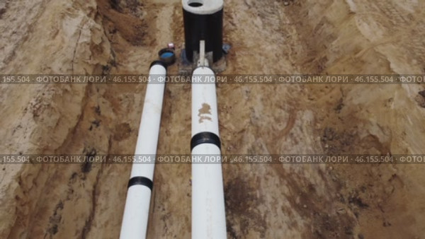 Two gleaming white conduits of engineering infrastructure buried beneath the surface. The site of a project involving the installation of gas, water, and oil pipelines. A close-up view of the camera. Стоковое видео, видеограф Скрипачев Антон / Фотобанк Лори