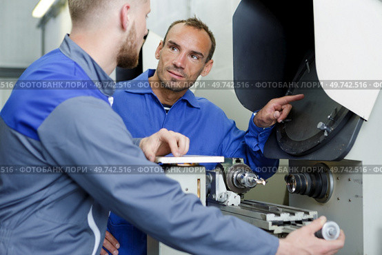 two happy positive mechanics working at workshop. Стоковое фото, агентство Ingram Publishing / Фотобанк Лори