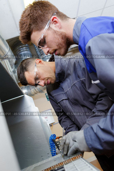 two men working on a machine. Стоковое фото, агентство Ingram Publishing / Фотобанк Лори