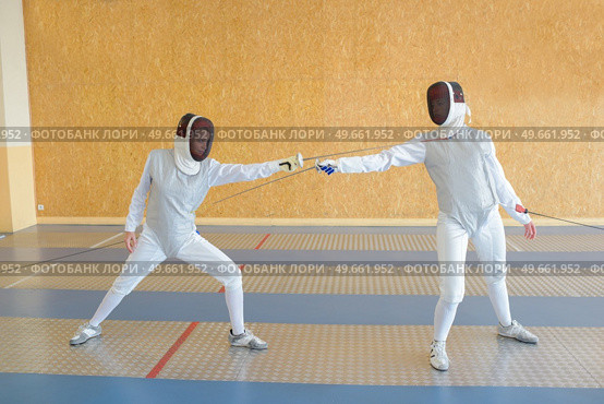 Two people in fencing combat. Стоковое фото, агентство Ingram Publishing / Фотобанк Лори