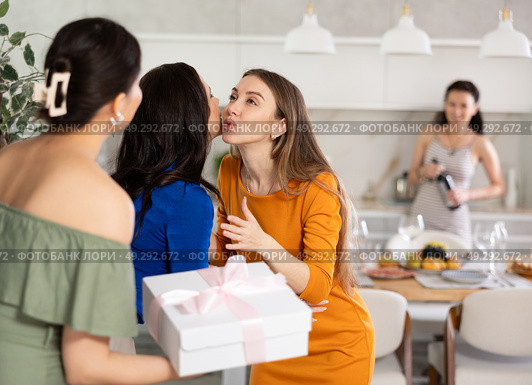 Two women have arrived for birthday celebration and presenting gift to birthday woman. Стоковое фото, фотограф Яков Филимонов / Фотобанк Лори