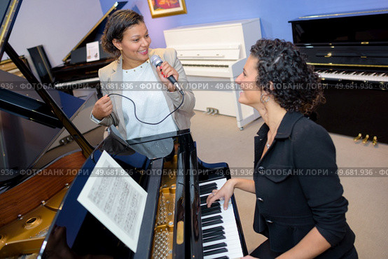 two women singing on the tune. Стоковое фото, агентство Ingram Publishing / Фотобанк Лори