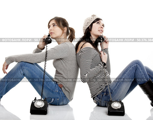 Two young women talking with old telephones - Isolated on white. Стоковое фото, агентство Ingram Publishing / Фотобанк Лори