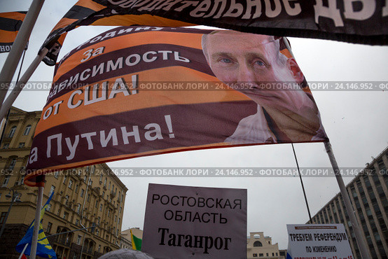 Участник шествия и митинга "Мы едины!" держит плакат с надписью "За независимость от США!" в российский праздник День народного единства на Тверской улице в городе Москве, Россия 4 ноября 2016. Редакционное фото, фотограф Николай Винокуров / Фотобанк Лори