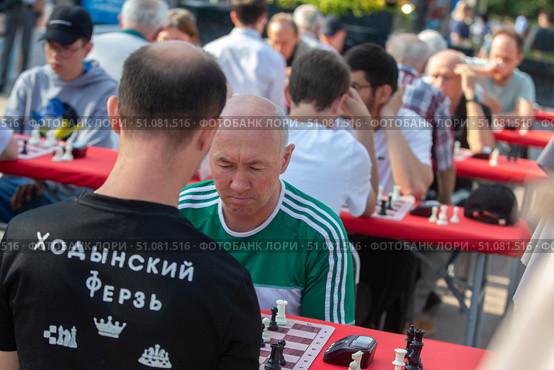 Участники турнира думают над шахматной партией во время проведения Дня физкультурника на площадке по шахматам на площади Революции в центре города Москвы, Россия. Редакционное фото, фотограф Николай Винокуров / Фотобанк Лори