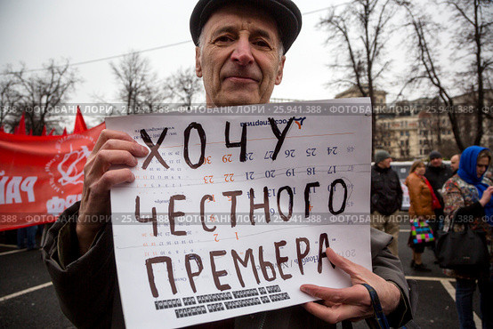 Участниr митинга КПРФ против ухудшения социального положения граждан России на площади Революции в городе Москве держит плакат с надписью "Хочу честного премьера" (2017 год). Редакционное фото, фотограф Николай Винокуров / Фотобанк Лори