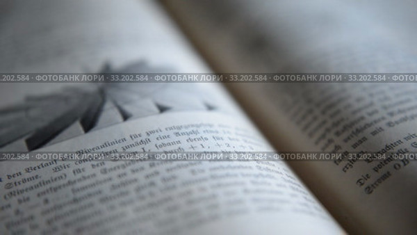 Ufa, Russia - FEB 15: man leafs through an old German physics textbook circa 1890 on February 14, 2015 in Ufa, Russia. Close up. Редакционное видео, видеограф Mikhail Erguine / Фотобанк Лори