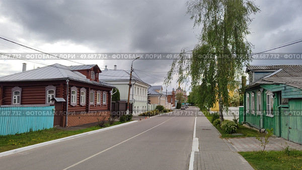 Улица в старинном провинциальном русском городе. Ухоженные деревянные и кирпичные дома, ровная асфальтированная дорога весенним днем. Чистый, аккуратный, благоустроенный городской район. Россия, Коломна, 11 мая 2025. Street in ancient provincial Russian city. Well-maintained wooden and brick houses, smooth paved road on spring day. Clean, tidy, manicured urban area. Kolomna, Russia, May 11, 2025. Стоковое фото, фотограф Ирина / Фотобанк Лори