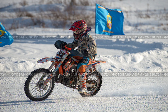 Юный спортсмен во время открытого зимнего кубка ДОСААФ Russian MX-Speedway 2017 в Брехово. Редакционное фото, фотограф Pukhov K / Фотобанк Лори