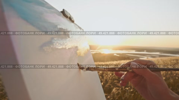 Using paintbrush and canvas, the young artist creates beautiful and atmospheric landscape that captures feeling of warm summer day. Стоковое видео, видеограф Strunov David / Фотобанк Лори
