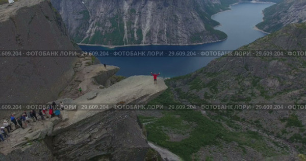 Утес Trolltunga (Язык Тролля). Очередь на край скалы для фотографирования, человек подходит к краю. Норвегия (2018 год). Редакционное видео, видеограф Кекяляйнен Андрей / Фотобанк Лори