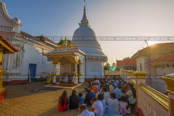 Утренняя  молитва в буддистском храме Kande Viharaya Temple. Берувала, Шри-Ланка (2020 год). Редакционное фото, фотограф Виктор Карасев / Фотобанк Лори