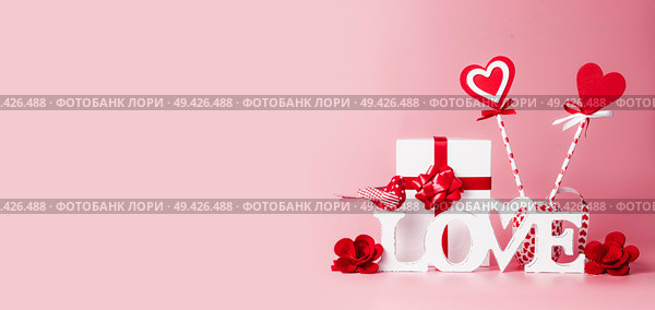 Valentines day background. Word Love, gift box, red ribbons and hearts lollipops. Festive greeting concept. Romantic Love declaration concept. Copy space for your design. Banner. Стоковое фото, агентство Ingram Publishing / Фотобанк Лори