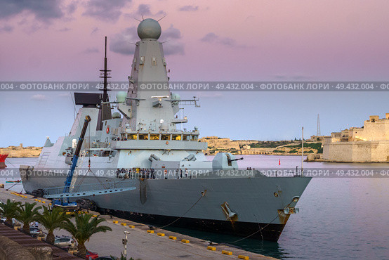 Valletta, Malta - Nov 7 2018, Panoramic view of the moored warship HMS Duncan D37 at sunset, without people, in the port of Valletta, Malta. Редакционное фото, фотограф Сергей Богомяко / Фотобанк Лори