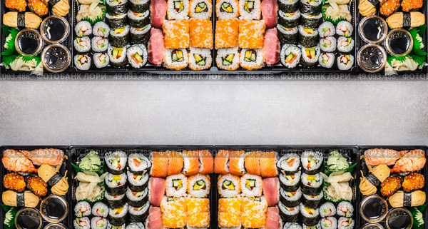 Varied Sushi sets assortment in bento boxes on gray stone background, top view, horizontal border or banner.  Japanese and Asian food. Стоковое фото, агентство Ingram Publishing / Фотобанк Лори