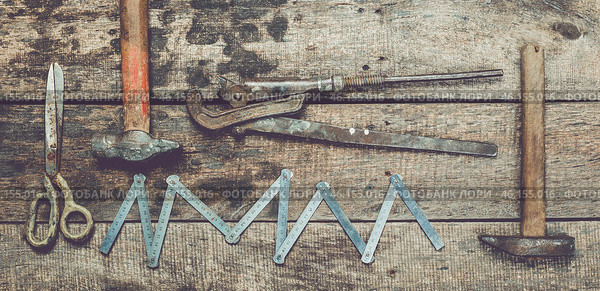 Various hand tools arranged on a rustic wooden surface for repair and construction activities. Стоковое фото, фотограф Сергей Толмачёв / Фотобанк Лори