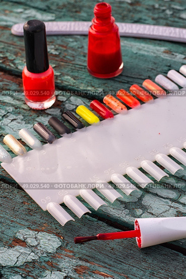 varnish for nail polish. Tubes with varnish for nail polish of different colors on an old wooden background. Стоковое фото, агентство Ingram Publishing / Фотобанк Лори