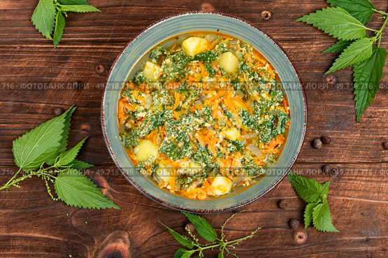 Vegan nettle soup on old rustic wooden table. Top view.. Vegan seasonal nettle soup. Стоковое фото, агентство Ingram Publishing / Фотобанк Лори