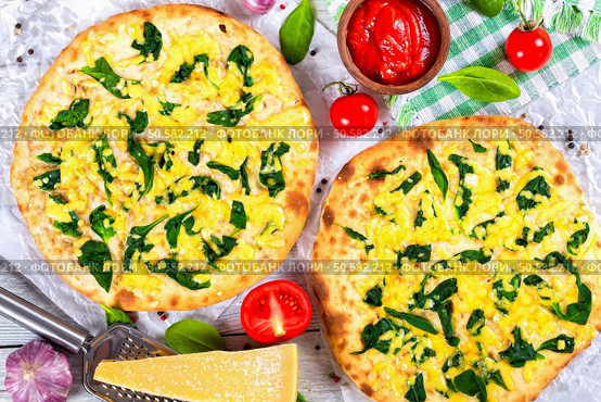 Vegetarian pizza with spinach leaves, parmesan cheese. tomatoes and homemade salsa in bowl, pepper, garlic and grater with piece of parmesan cheese on wooden boards, close-up, top view. Стоковое фото, агентство Ingram Publishing / Фотобанк Лори