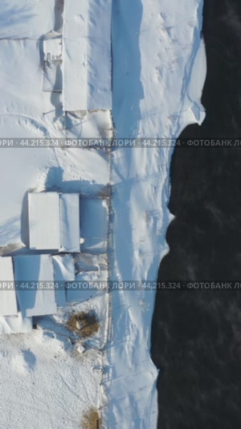 Vertical video from drone on Altai country village Semiletka in winter. Camera looks down. River Koksha with banks covered by snow. Стоковое видео, видеограф Сергей Пристяжнюк (Serg Zastavkin) / Фотобанк Лори