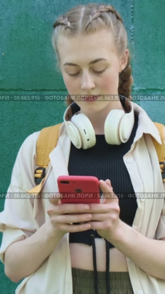 Vertical video. Gen Z young woman chats with friends using smartphone outdoors. Стоковое видео, видеограф Маргарита Кирьякова / Фотобанк Лори