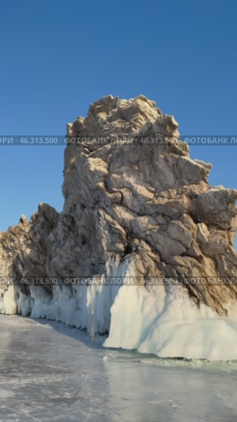 Vertical video of frozen Baikal Lake in winter sunny day. View of natural landmark Dragon Cape on edge of Ogoy Island from Small Sea Strait ice surface. Popular place of tourists. Scenic landscape. Стоковое видео, видеограф Виктория Катьянова / Фотобанк Лори